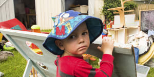 Mallacoota preschooler Tom Brownlie watches on as mould-damaged equipment is thrown away on Monday.