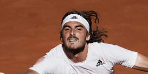 Stefanos Tsitsipas reaches for the ball against Novak Djokovic.