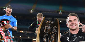 Edwards celebrates with the premiership trophy and the Clive Churchill Medal in 2022.