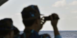 Vietnamese sailors watch the approach of a Chinese coast guard vessel near the Paracel Islands.