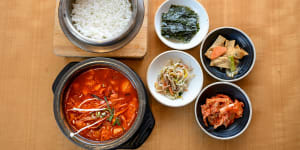 The signature tofu soup,sundubu-jjigae (bottom left),comes with banchan (snacks) and rice.