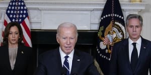 US President Joe Biden,center,speaks with Secretary of State Antony Blinken,right,and Vice President Kamala Harris in the State Dining Room of the White House.