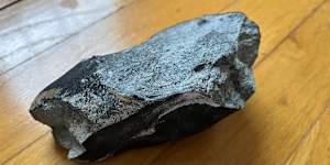 The family who owns the home discovered the black,potato-sized rock - seen here turned over - in a corner still warm.