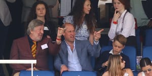 The author’s tutor of matters of cricket,Marylebone Cricket Club president Stephen Fry,in the stands with Prince William and Prince George on Saturday.