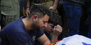 Mourners gather in grief around the grave of Israeli soldier Captain Harel Ittah during his funeral in Netanya,Israel.