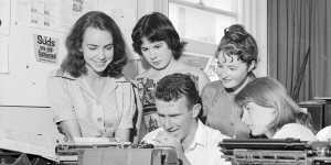 Clive James typing the University of Sydney's issue Honi Soit while,from left,Marie Taylor,Jane Iliff,Madeleine St John and Sue McGowan watch him as the editor,David Ferraro,and Helen Goldstein plan other pages on February 23,1960.