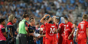 Adelaide players take a drinks break during the match with Sydney FC on Saturday night. 