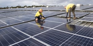 Rohan Dux and Daniel Young install solar panels in Heathwood,Queensland.