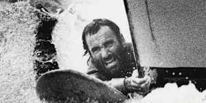 “Ian Cohen hangs on to the bow of the USS Oldendorf in the harbour yesterday.”