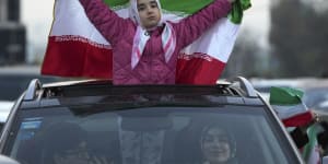 An Iranian girl holds up her country’s flag in Sadeghieh Square. in Tehran.