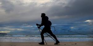 Gareth Andrews pulls tyres along Manly Beach during training for The Last Great First,a 110-day trek across Antarctica.