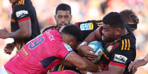 Samisoni Taukei’aho of the Chiefs is tackled by the Rebels.
