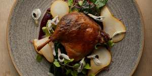 Confit duck leg with pears and broad bean flowers.