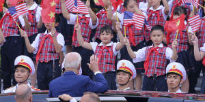 Joe Biden waves to children after a military welcome ceremony at the Presidential Palace in Hanoi,Vietnam,on Sunday.