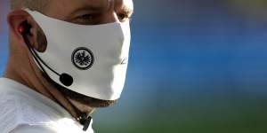 A member of Frankfurt's coaching staff wears a mask on the sidelines.
