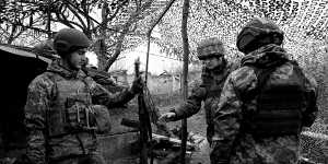 Soldiers in Ukraine’s 30th Brigade discuss their weaponry in a trench in the Donbas region.
