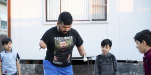 'It's hard to balance':Ghanim al-Shnen plays football with his sons,who will soon return to their home in Finland. 