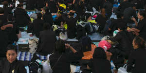 Thai mourners sits in front of the Royal Crematorium and funeral complex ahead of King Bhumibol cremation.