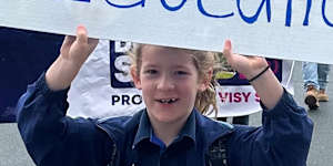Students and parents held placards and banners in front of West End State School on Monday.