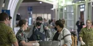 Passengers from San Francisco arrive at Sydney International Airport before being transported to hotel quarantine on Wednesday evening.