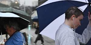 Pedestrians brave the wet and stormy conditions in Double Bay on Wednesday.