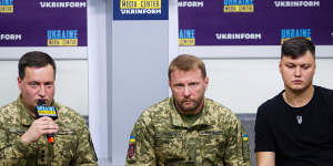 Russian helicopter pilot Maxim Kuzminov (right) at press conference in September 2023 with two Ukrainian military personnel after defecting.