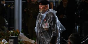 A returned serviceman at the Cenotaph in the rain for the Anzac Day dawn service.