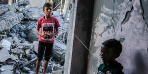 Children stand in a building destroyed during Israeli air raids in the southern Gaza Strip,on November 6. Thousands of children have been killed in the air raids.