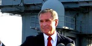 President Bush flashes a “thumbs-up” after declaring the end of major combat in Iraq in May 2003. The country would be convulsed by violence for years afterward.