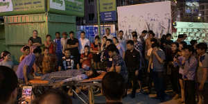 A woman is tended to after she was assaulted in a casino carpark in Sihanoukville,Cambodia.