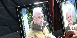 A Wagner mercenary with portraits of Wagner boss Yevgeny Prigozhin and commander Dmitry Utkin at a memorial that sprung up outside a Wagner office in Novosibirsk.