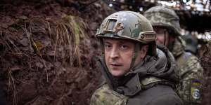 Ukrainian President Volodymyr Zelensky,walks under a camouflage net in a trench as he visits the war-hit Donetsk region,eastern Ukraine.