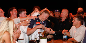 Caddy celebrates with family and friends after being picked up by the Bombers.
