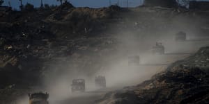 A convoy of Israeli troops moves in the Gaza Strip as seen from southern Israel on Thursday.