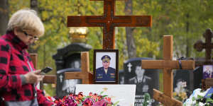 A woman walks past a tomb of Major General of Russian army Vladimir Frolov killed in Ukraine in April 2022 at the Serafimovskoye cemetery in St Petersburg,Russia.