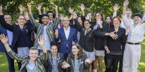Education Minister James Merlino (centre) and VCAA chief executive Stephen Gniel (far left) celebrate with year 12 graduates on the lawns of Parliament House.