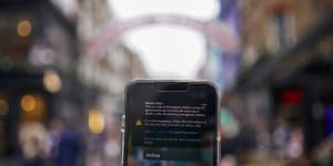 A smartphone displays the banner of an emergency alert system in London.