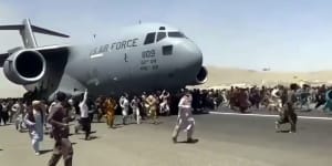 In August,with the Taliban takeover of Kabul,people run alongside a US Air Force transport plane as it moves down a runway of the international airport.