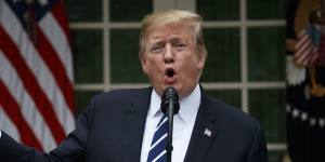 US President Donald Trump brandishes a sheet about the Mueller report at a surprise press conference in the White House Rose Garden. 