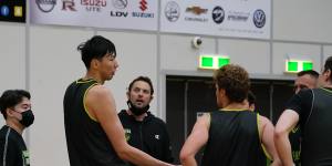 South East Melbourne Phoenix centre Zhou Qi gets to know assistant coach Luke Kendall and his teammates on Wednesday.