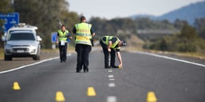 Victoria Police members investigate a crash on the Hume Freeway in 2017.