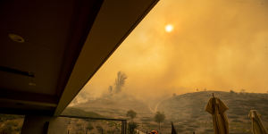 In California,an Orange County firefighter prepares to defend a home as the Silverado fire approaches a neighborhood in October 2020.