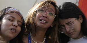 Mitzi Jonelle Tan,of the Philippines,embraces Adriana Calderon Hernandez (right) and other activists at a protest against fossil fuels during the COP28 conference in Dubai.