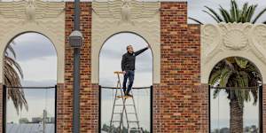 Traditional Restoration Company managing director James Ginter inspects the restored art deco wall at North Sydney Olympic Pool.