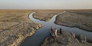 Residents prepare to travel into marshlands near Chibayish,Iraq. As water levels fall,the once verdant wetlands that formed a massive,shallow,reed-filled inland sea have been reduced to a thinning network of brackish canals.