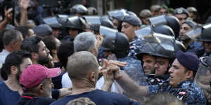 Lebanese riot police officers push back anti-bank protesters who arrived to support Bassam al-Sheikh Hussein.