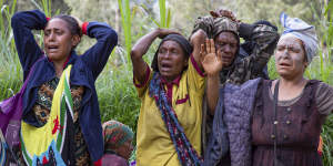 Grieving villagers in the devastated the village of Yambali.