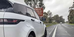 A car with two blown tyres on the side of the Hume Freeway.