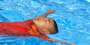 Children practise floating at a pool in Surat Thani using a second hand water bottle as a flotation device. 
