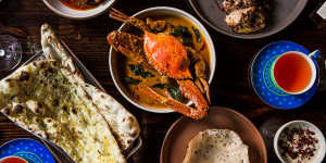 Clockwise from top left:Laal maas (meat curry),pepperberry chicken,nandu kuzhambu (crab curry),appam,garlic naan.